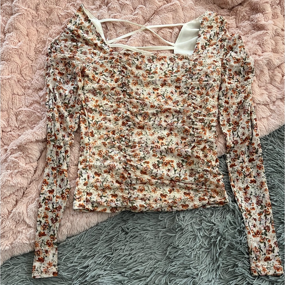 Floral mesh sleeve top with ruching and detailed back.